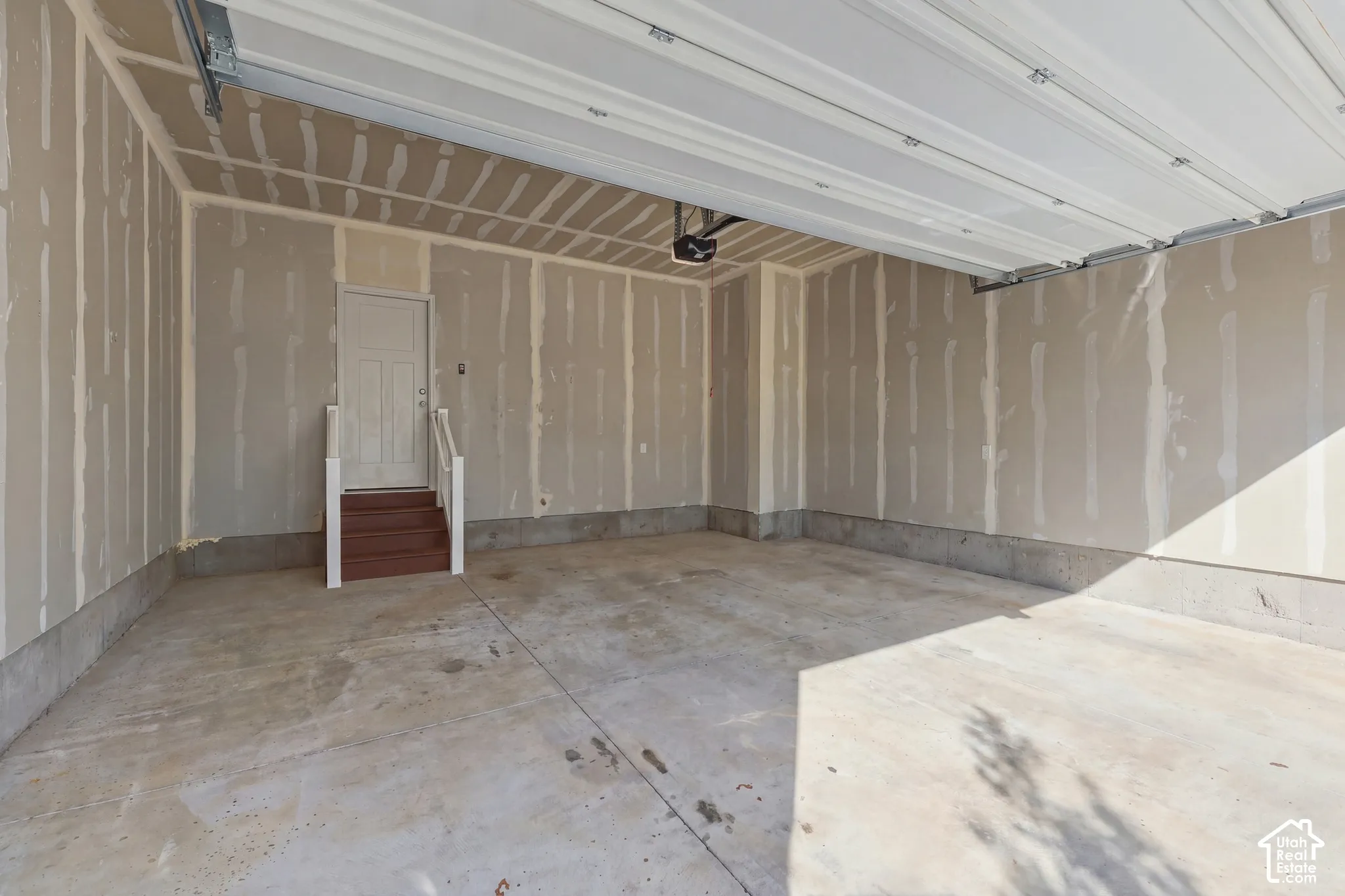 Concrete flooring in garage with interior access door