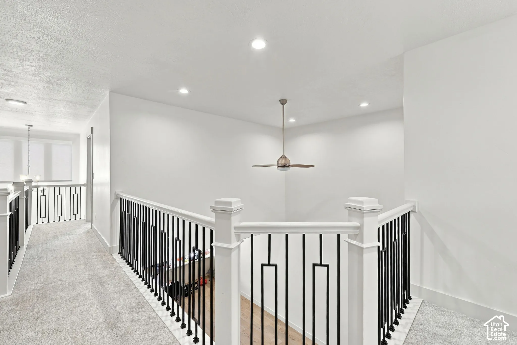 Spacious hallway featuring recessed lighting, a modern ceiling fan, and white painted walls