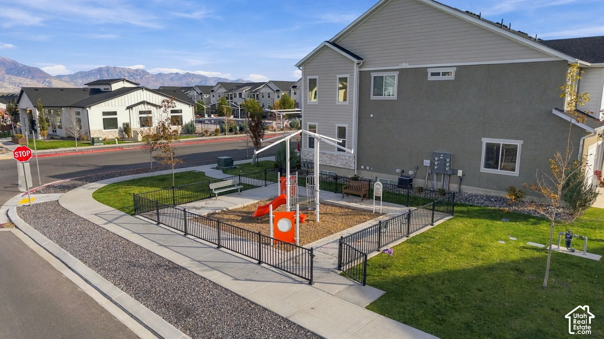 Community playground with fenced perimeter and seating areas