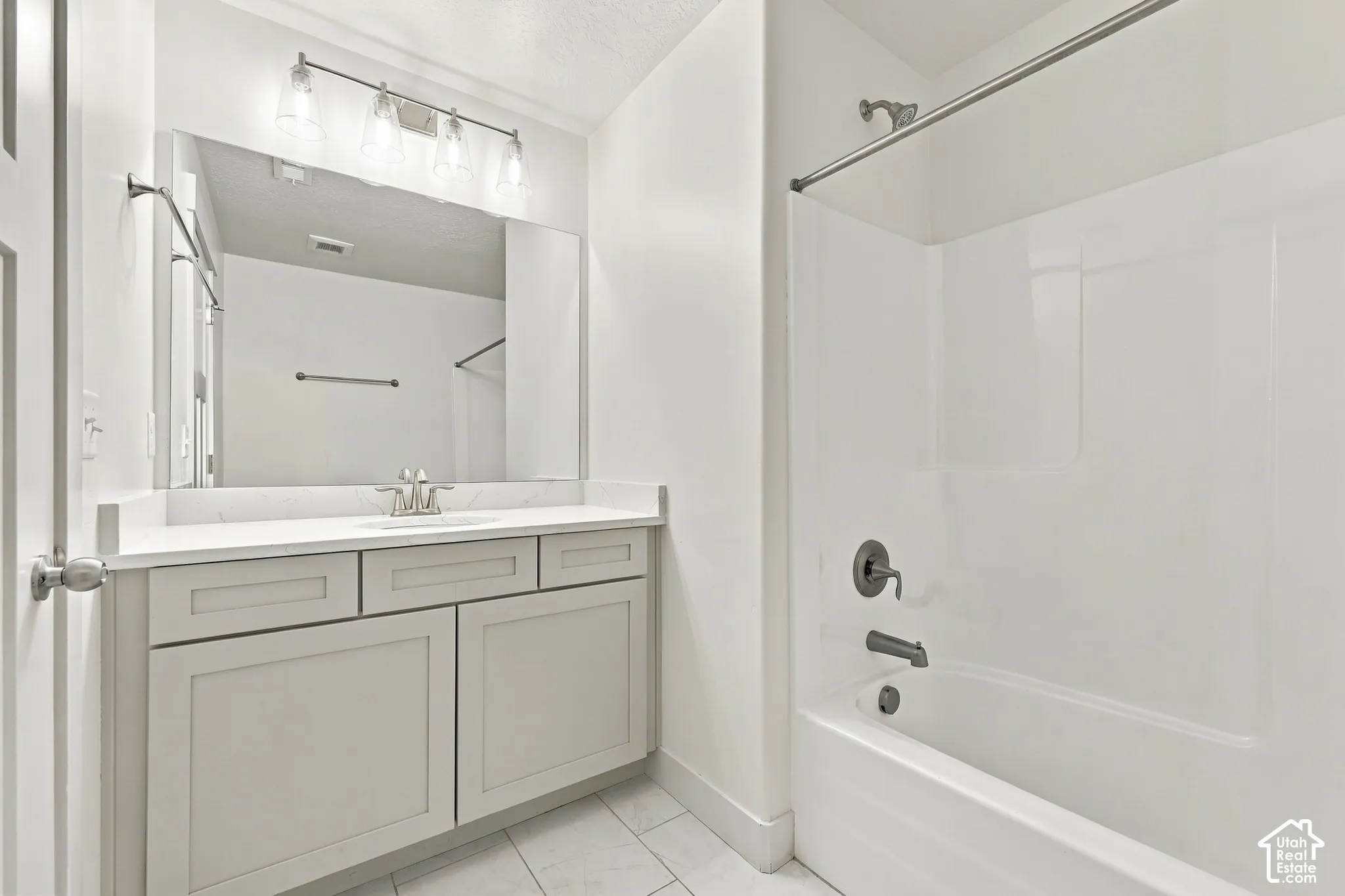 Bathroom featuring a single vanity with shaker-style cabinetry, a white countertop, and a large mirror