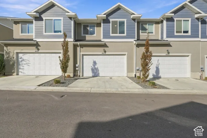 Exterior featuring stucco and siding finishes, multiple windows, attached garages, and concrete driveways