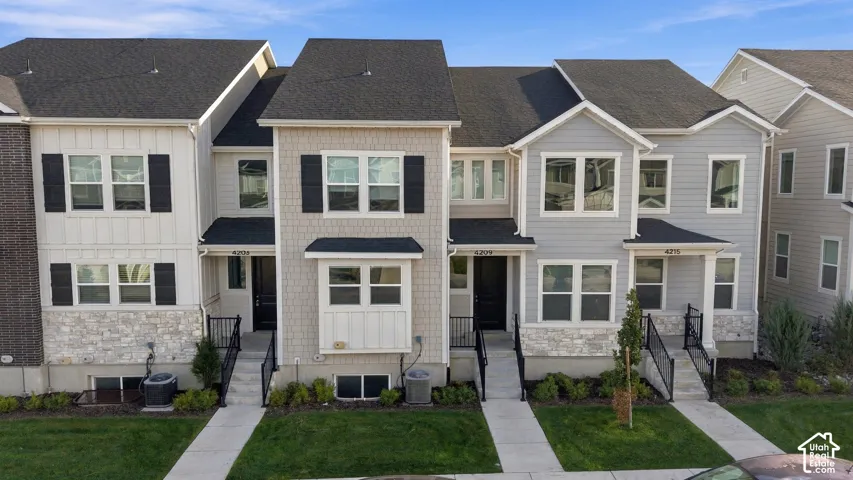 Contemporary multi-unit residence with varied siding, stone accents, and black shutters