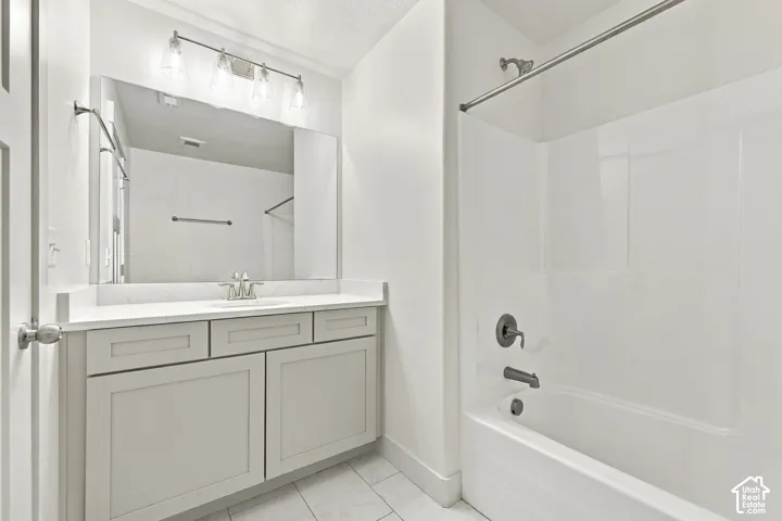 Bathroom featuring a single vanity with shaker-style cabinetry, a white countertop, and a large mirror