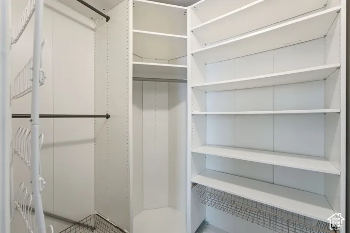 Custom closet system featuring multiple shelving units, hanging rods, and wire baskets