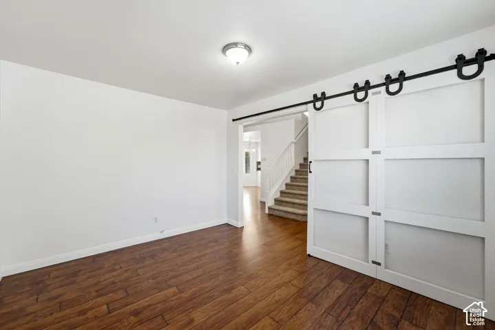 Wood-finish flooring with white walls and a flush-mount ceiling light