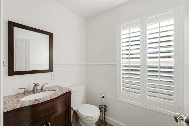 Dark wood-finish vanity with a light-toned countertop, set against wainscoting