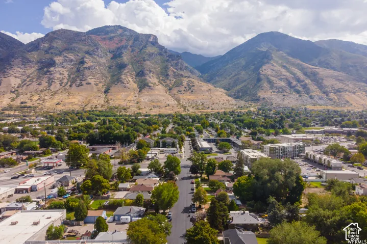 Expansive mountain backdrop with a developed residential and commercial area featuring mature trees and established infrastructure
