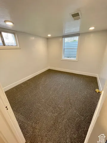 Wall-to-wall carpet flooring, two windows, and recessed ceiling lighting