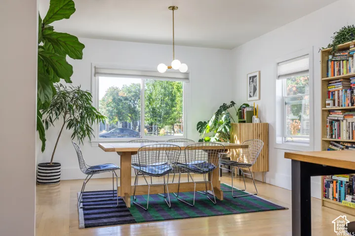 Hardwood flooring, recessed lighting, and a modern brass chandelier