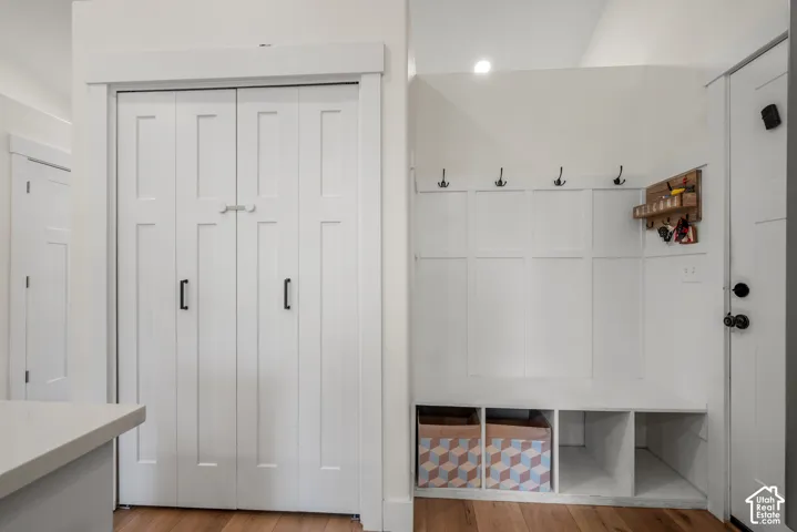 Built-in mudroom bench with storage cubbies, decorative wall paneling, and wall-mounted hooks