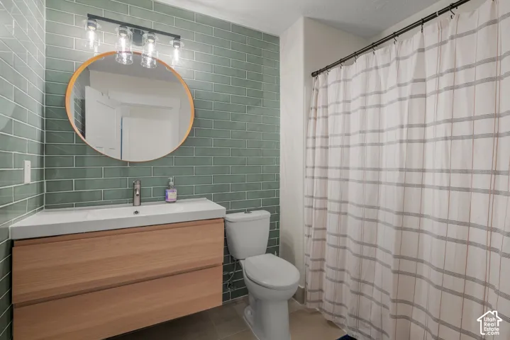Floating wood-finish vanity with an integrated basin, contemporary wall-mounted mirror, and subway tile accent wall