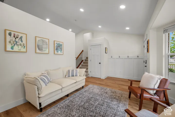 Recessed lighting illuminates the space, featuring wood-finish flooring and white walls