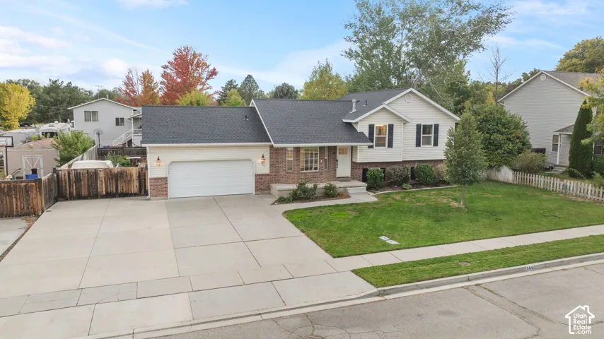 Traditional-style residence featuring a dark shingle roof and a two-car garage
