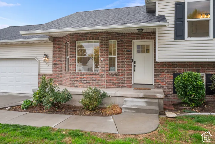 Brick and siding exterior with a concrete front porch and steps