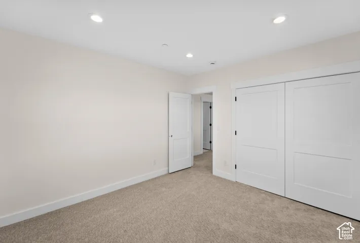 Recessed lighting, light-toned carpeting, white interior doors, and crisp white trim