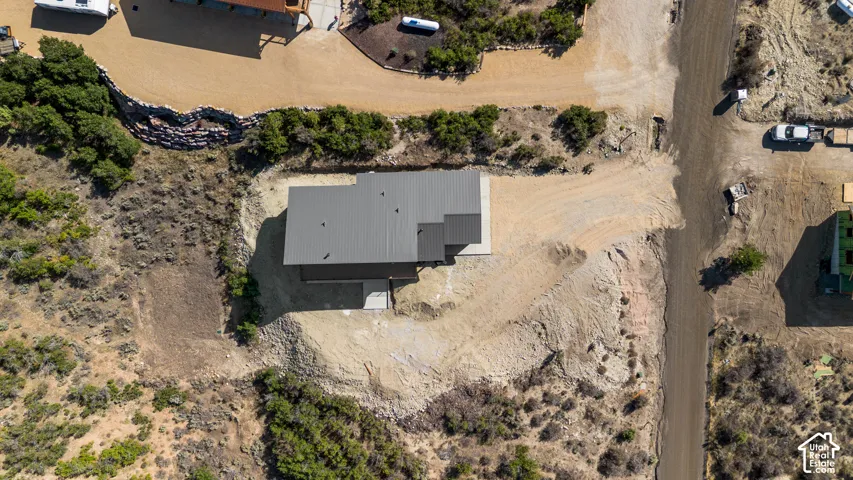Contemporary home with a dark metal roof, surrounded by natural terrain