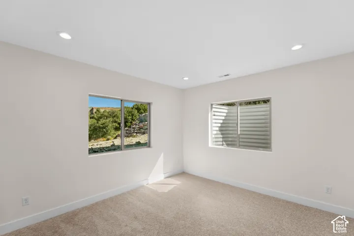 Recessed lighting, light-toned walls, and carpet flooring