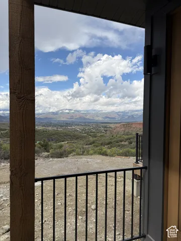 Balcony with black metal railing, offering expansive mountain scenery