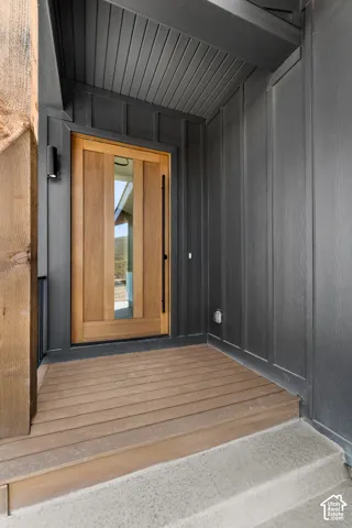 Modern wood-panel entry door with vertical glass panels and a black pull handle