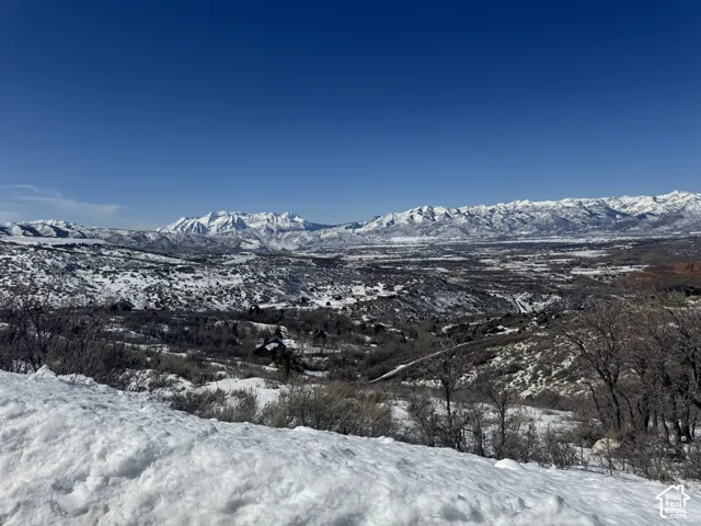 Expansive mountain range backdrop with snow-covered peaks and a broad valley