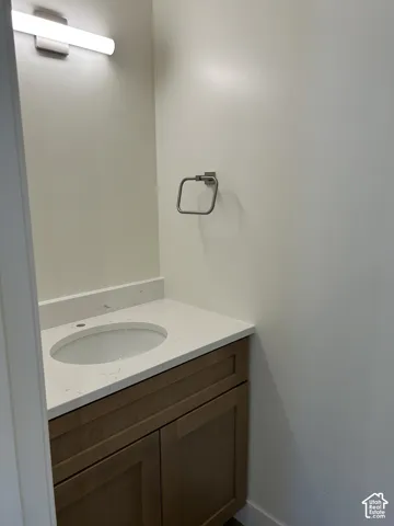 Integrated vanity with an undermount sink, light-toned countertop, and wood-finish cabinetry