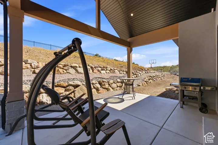 Covered concrete patio with recessed lighting, supported by a large column