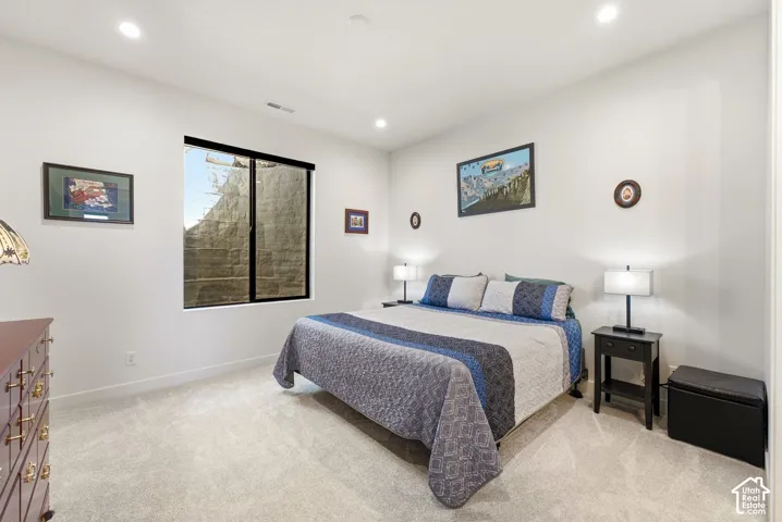 Recessed lighting, wall-to-wall carpeting, and a window with a black frame