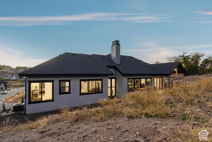 Contemporary exterior with a dark shingle roof, light-toned siding, and black-framed windows