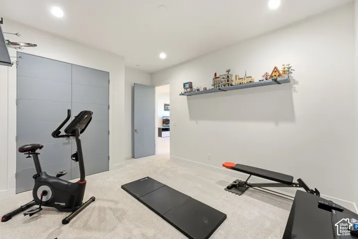 Recessed lighting, light-toned carpeting, and a built-in wall shelf