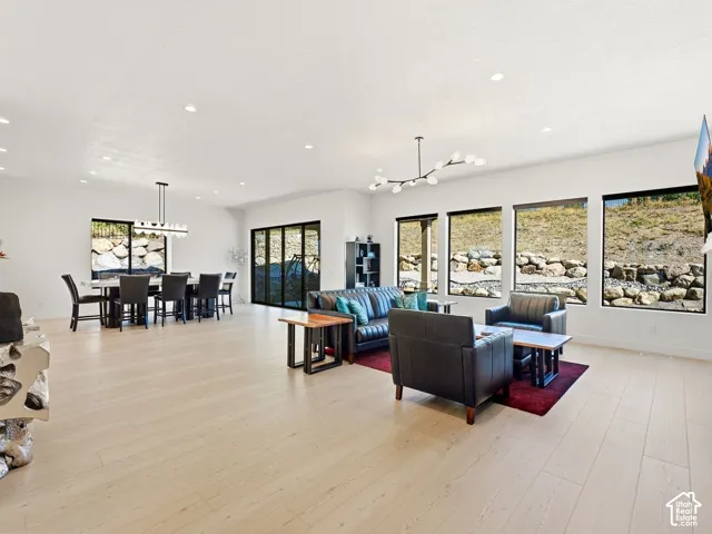 Open-concept interior featuring light wood-finish flooring, recessed lighting, and expansive windows
