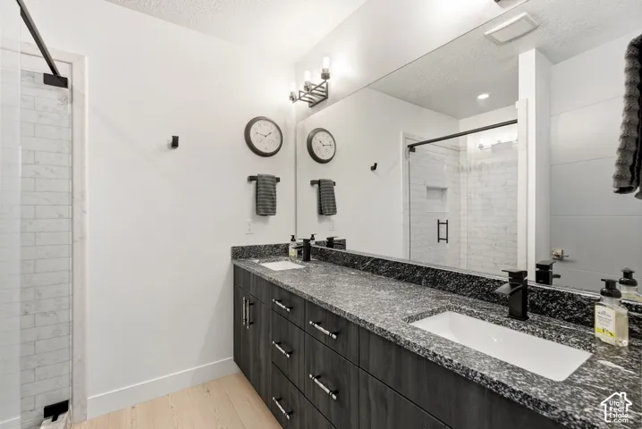 Double vanity with a speckled countertop, undermount sinks, and matte black faucets