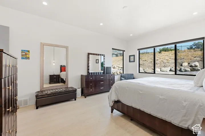 Recessed lighting, light wood-finish flooring, and expansive windows