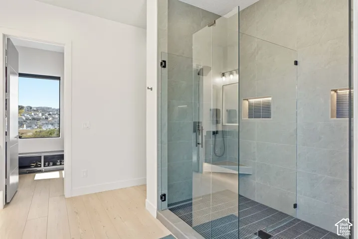 Spacious walk-in DOUBLE shower with glass enclosure, integrated bench, built-in niches, and textured tile flooring