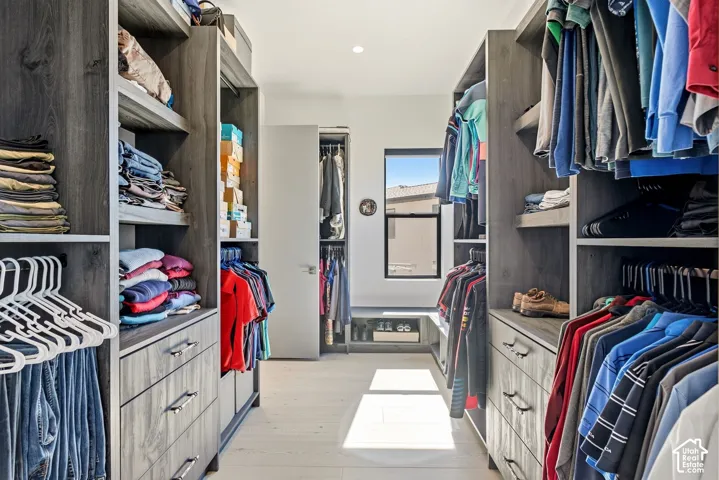 Custom closet system with wood-finish cabinetry, integrated shelving, and multiple hanging rods