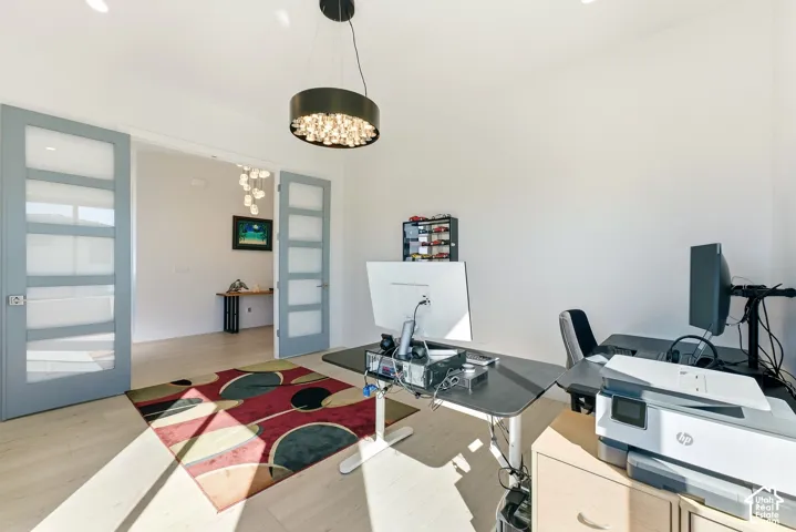 Recessed lighting throughout, wood-finish flooring, and a contemporary chandelier