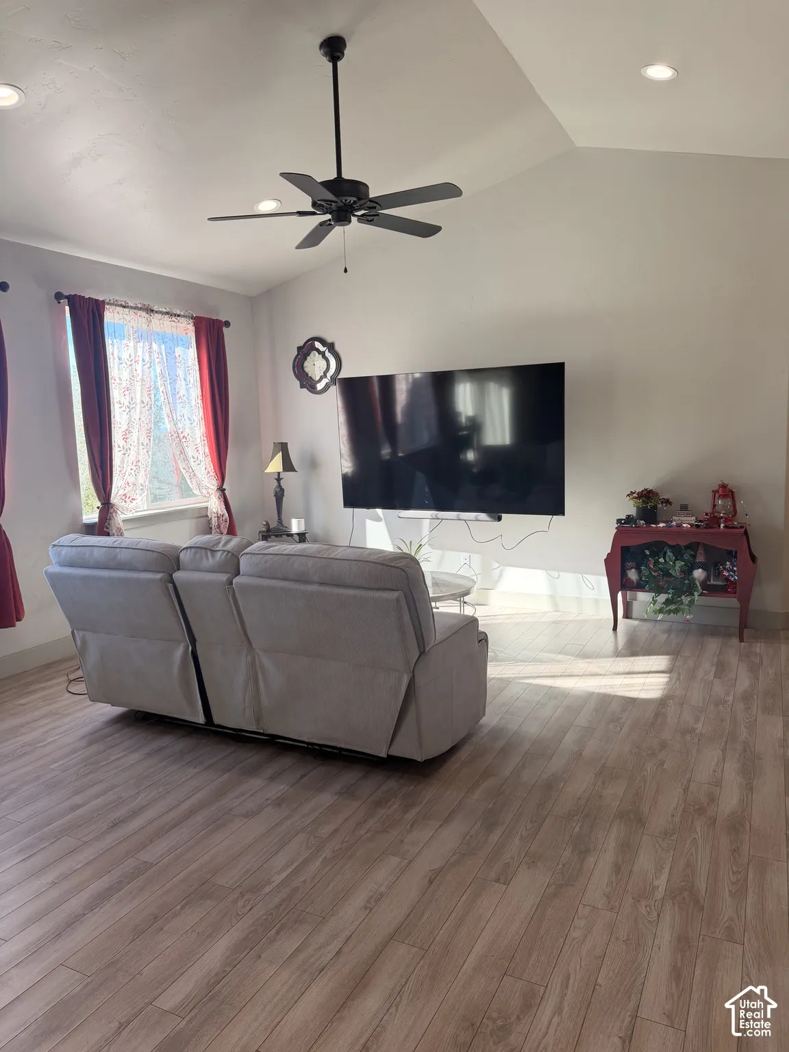 Vaulted ceiling with a ceiling fan, recessed lighting, and wood-finish flooring