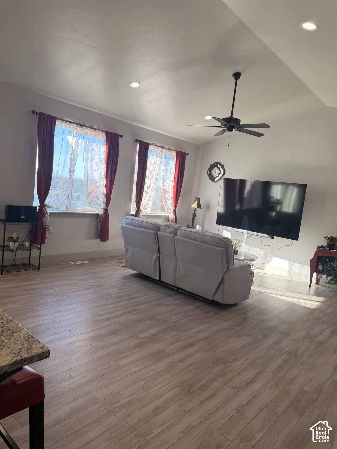 Recessed lighting, sloped ceiling, wood-finish flooring, ceiling fan, and prominent windows