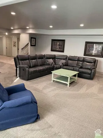 Recessed lighting illuminates the carpeted flooring and light-toned walls