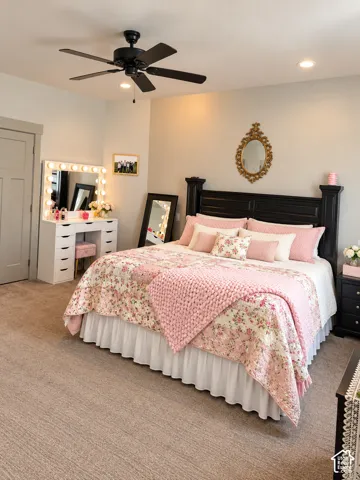 Recessed ceiling lighting, ceiling fan, neutral carpet flooring, and a dark wood-finish headboard