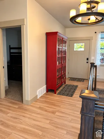 Wood-finish flooring, recessed lighting, and a chandelier fixture