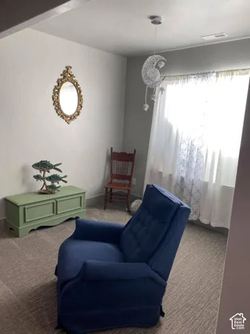 Wall-to-wall carpeting and white walls with a window featuring sheer white curtains