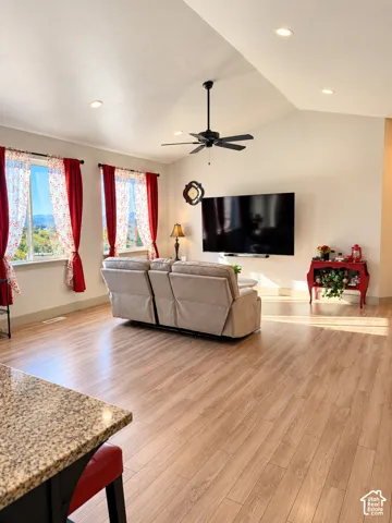 Vaulted ceilings with recessed lighting and a ceiling fan