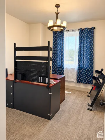 Recessed window with natural light, textured carpet flooring, and a ceiling-mounted chandelier
