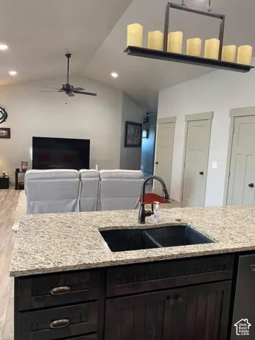 Kitchen island featuring a double basin sink, bronze-finish faucet, and granite-style countertop