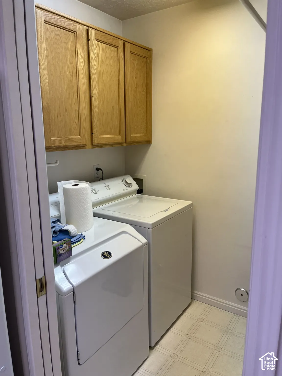 Built-in wood-finish cabinetry, neutral wall paint, and patterned vinyl flooring