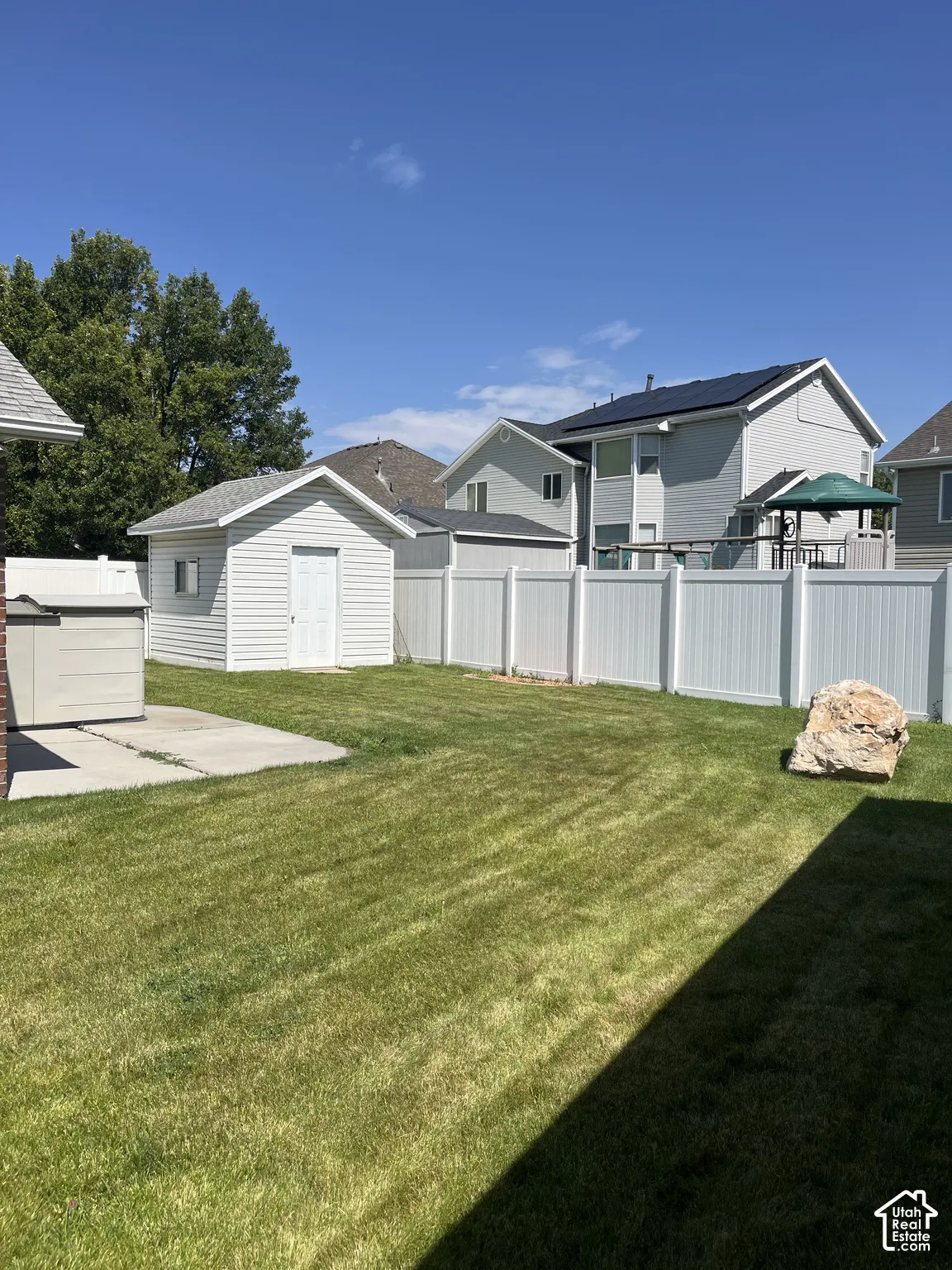 Expansive lawn area with a white vinyl privacy fence