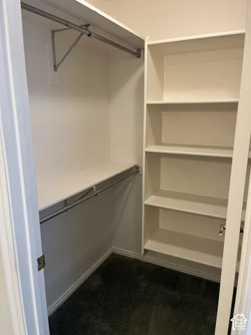 Built-in shelving, two hanging rods, and an overhead shelf provide storage within this closet space
