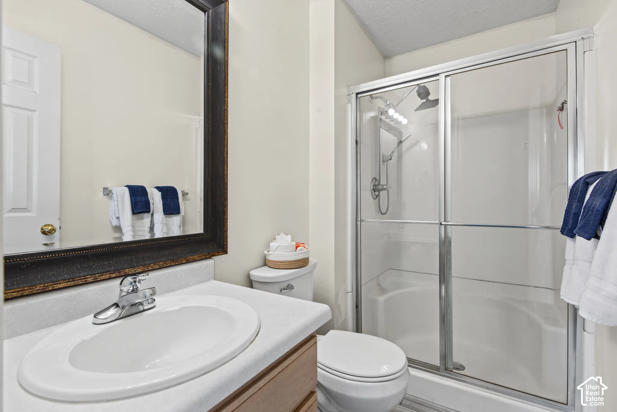 Bathroom featuring a chrome faucet, white oval sink, and a framed mirror
