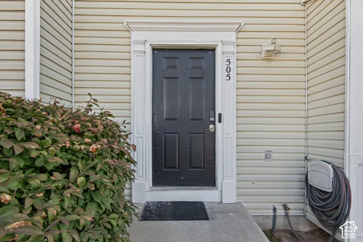 Entry featuring a panel door, decorative door trim, and siding exterior