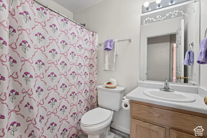 Bathroom with a wood-finish vanity, integrated sink, and wall-mounted mirror
